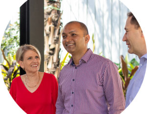 Header image of three AGPAL staff, a woman with short blonde hair in a red top, a man in a chequered business shirt and another man talking