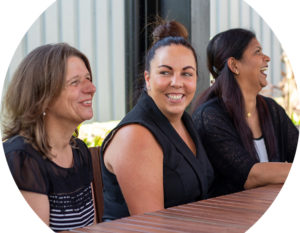 Header image of three AGPAL staff at a bench and table near a garden, all smiling and laughing