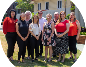 Image of nine members of the AGPAL & QIP Education and Training Team in a garden