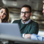 Young couple using computer with their insurance agent on a meeting in the office.