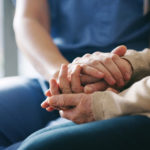 Cropped shot of a senior woman holding hands with a nurse