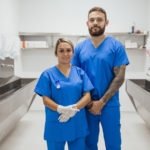 A shot of two healthcare workers smiling looking at the camera.