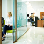 Indoor shot of dentist clinic with patients standing at reception and waiting in a waiting room