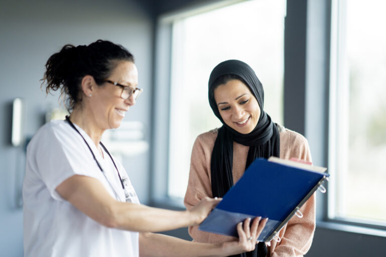 A healthcare professional interacts with a female patient in a clinical environment, discussing medical considerations. The setting features medical equipment and conveys professionalism and trust in healthcare services.